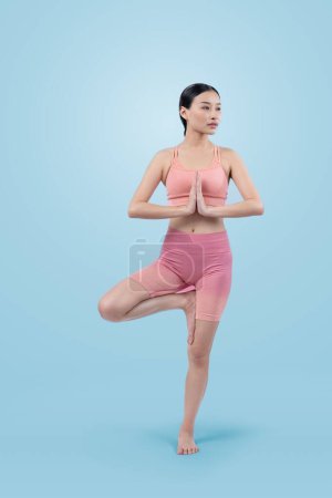 Foto de Mujer asiática en ropa deportiva haciendo ejercicio de yoga en pose de pie en la aptitud como su rutina de entrenamiento. Cuidado corporal saludable y meditación yoga estilo de vida en plena toma sobre fondo aislado. Vigoroso - Imagen libre de derechos