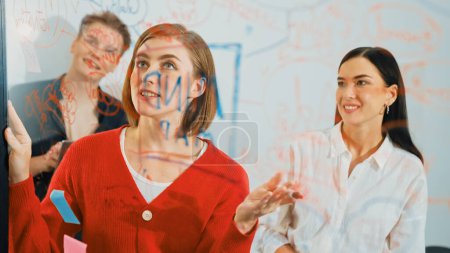 Photo for Professional business team brainstorming and working together about marketing project. Female caucasian leader writing idea on stick note while coworker present her idea confidently. Immaculate. - Royalty Free Image