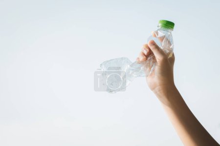 Téléchargez les photos : Bouteille en plastique recyclable tenue à la main sur fond de ciel. Tenir à la main les déchets plastiques pour les recycler réduit et réutilise le concept pour promouvoir un environnement propre grâce à une gestion efficace du recyclage. Pneumatique - en image libre de droit