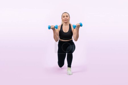 Photo for Full body length shot active and sporty senior woman lifting dumbbell during weight training workout on isolated background. Healthy active physique and body care lifestyle for pensioner. Clout - Royalty Free Image