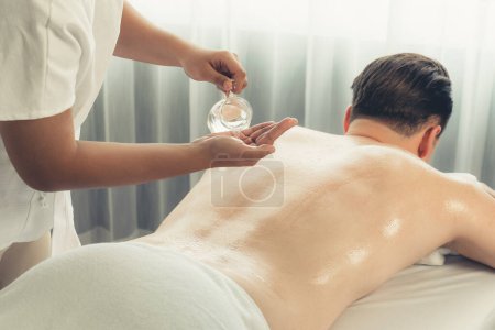 Photo for Masseur hands pouring aroma oil on man back. Masseuse prepare oil massage procedure for customer at spa salon in luxury resort. Aroma oil body massage therapy concept. Quiescent - Royalty Free Image