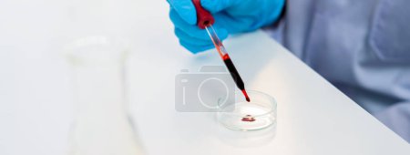 Photo for Scientific laboratory researcher drop blood sample on microscopic slide for medical examination or develop new diagnostic tool. Microbiologist or medical worker conduct experiment in lab. Rigid - Royalty Free Image