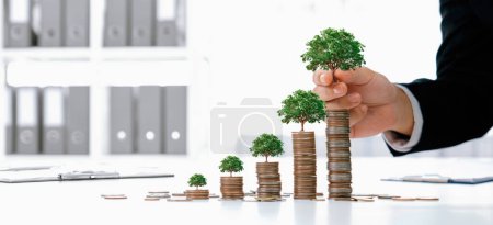 Téléchargez les photos : La pile de pièces de croissance avec arbre sur le dessus symbolise l'investissement des entreprises vertes sur la RSE ou l'ESG pour la protection de l'environnement. Les gens d'affaires qui font de la planification financière pour archiver la durabilité zéro nette. Perspicace - en image libre de droit
