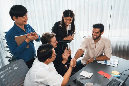 Photo for Diverse group of office employee worker shake hand after making agreement on strategic business marketing meeting. Teamwork and positive attitude create productive and supportive workplace. Prudent - Royalty Free Image