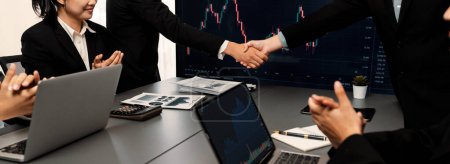 Photo for Stock investors celebrate successful profit from selling stock and shaking hand with each other, market analysis and strategic decision-making led to successful stock trading exchange. Trailblazing - Royalty Free Image