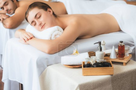 Téléchargez les photos : Massage aromathérapie à la lumière du jour ou configuration de salon de spa avec décor de mise au point et accessoires de spa sur femme floue profitant d'un massage aromatique spa dans un cadre de villégiature ou d'hôtel. Tranquillité - en image libre de droit