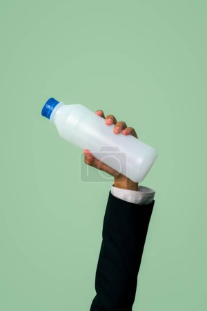 Téléchargez les photos : Businessmans main tenant bouteille en plastique sur fond isolé. L'éco-entreprise recycle la politique des déchets dans la responsabilité d'entreprise. Réutiliser, réduire et recycler pour un environnement durable. Charmante. - en image libre de droit