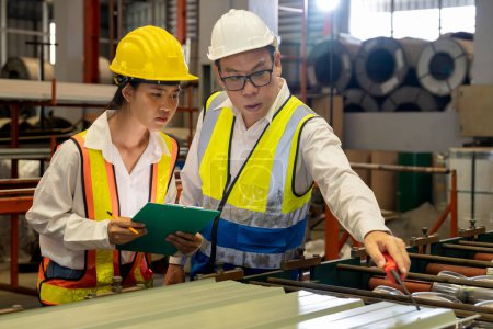 Photo for Factory engineer manager collaborate with coworker to conduct quality control on metal sheet product and inspect heavy industrial steel stamping or forming machine. Exemplifying - Royalty Free Image