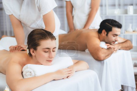 Photo for Caucasian couple customer enjoying relaxing anti-stress spa massage and pampering with beauty skin recreation leisure in day light ambient salon spa at luxury resort or hotel. Quiescent - Royalty Free Image