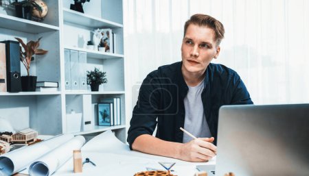 Photo for Portrait of architect designer sit at desk in office, brainstorm idea for architectural design project, drafting blueprint with laptop. Professional and modern technology in architecture. Iteration - Royalty Free Image