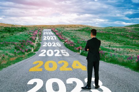 Photo for 2024 New Year journey and future vision concept . Businessman traveling on highway road leading forward to happy new year celebration in beginning of 2024 for bliss and successful start . - Royalty Free Image