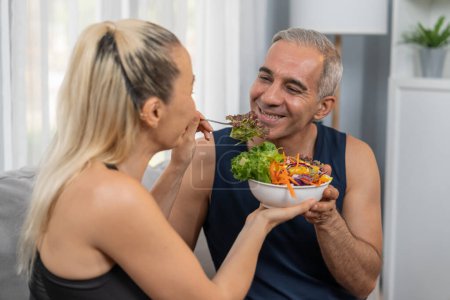 Photo for Healthy senior couple in sportswear with a bowl of fruit and vegetable. Healthy cuisine nutrition and vegan lifestyle for fitness body physique concept. Clout - Royalty Free Image