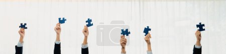 Photo for Panorama banner of business team assembling jigsaw puzzle over table symbolize business partnership and collective teamwork for HR recruitment and job seeker background. Shrewd - Royalty Free Image