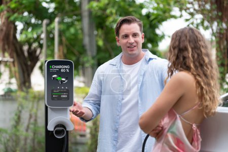 Photo for Happy and lovely couple with eco-friendly conscious recharging electric vehicle from EV charging station. EV car technology utilized as alternative transportation for future sustainability. Synchronos - Royalty Free Image