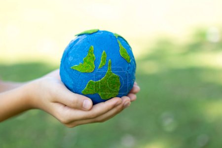 Photo for Young boys hand holding planet Earth globe at natural park background as Earth day to save this planet with ESG principle and environment friendly energy for brighter future. Gyre - Royalty Free Image