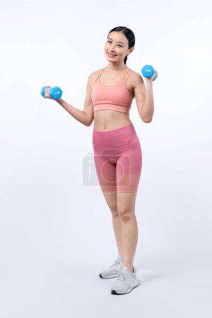 Photo for Vigorous energetic woman doing dumbbell weight lifting exercise on isolated background. Young athletic asian woman strength and endurance training session as body workout routine. - Royalty Free Image