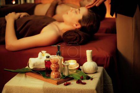 Photo for Aromatherapy massage ambiance or spa salon composition setup with focus decor candles and spa accessories on blur couple enjoying blissful aroma spa massage in resort or hotel background. Quiescent - Royalty Free Image