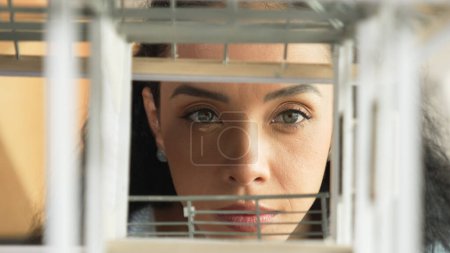 Photo for Closeup image of young hispanic architect engineer inspect house model construction. Project manager looking inside building while checking architectural model structure. Focus on face. Manipulator. - Royalty Free Image