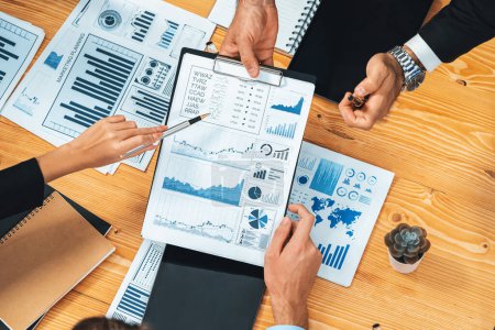 Photo for Top view diverse group of business analyst team analyzing financial data report paper on meeting table. Chart and graph dashboard by business intelligence analysis. Meticulous - Royalty Free Image