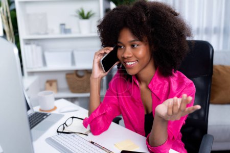 Photo for African woman talking with coworker or friend on the phone and looking at the screen with happy face. Achievement for promoting job position in the company with the good news life. Tastemaker. - Royalty Free Image