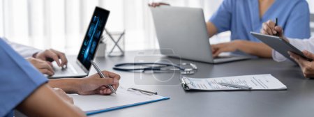 Photo for Doctor and nurse in medical meeting discussing strategic medical treatment plan together with report and laptop. Medical school workshop training concept in panoramic banner. Neoteric - Royalty Free Image