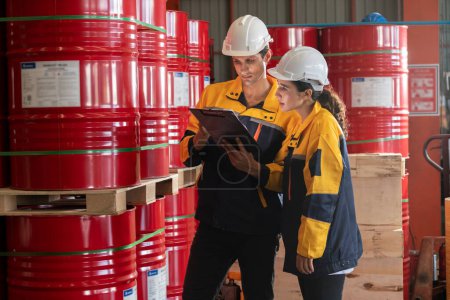 Photo for Two factory workers or inventory inspector conduct professional inspection on hazardous chemical barrels in warehouse, chemistry storage workplace and industrial profession concept. Exemplifying - Royalty Free Image
