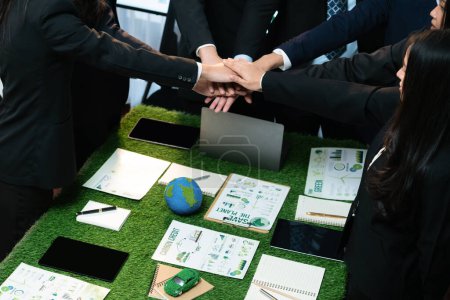 Téléchargez les photos : Synergie d'affaires entre les hommes d'affaires qui travaillent main dans la main pour renforcer l'éco-réglementation en matière de protection de l'environnement en réduisant les émissions de CO2 afin de contribuer à un avenir durable. Charmante. - en image libre de droit
