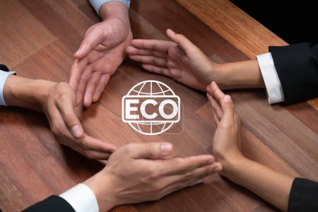 Photo for Top view group of business people forming circle hand together around ECO icon on meeting table as concept of corporate responsible for eco-friendly investment for greener community. Quaint - Royalty Free Image