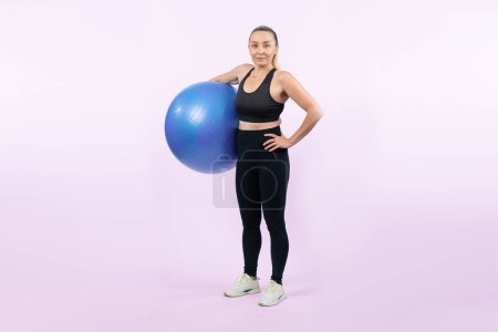 Photo for Full body length shot athletic and sporty senior woman with fitness exercising ball on isolated background. Healthy active and body care lifestyle after retirement. Clout - Royalty Free Image