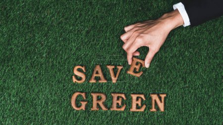 Photo for Hand arrange wooden alphabet in ECO awareness campaign design on biophilia green grass background to promote environmental protection for greener and sustainable future. Gyre - Royalty Free Image