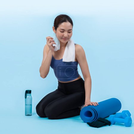 Photo for Athletic and sporty asian woman resting after intensive cardio workout training. Healthy exercising and fit body care lifestyle pursuit in studio shot isolated background. Vigorous - Royalty Free Image