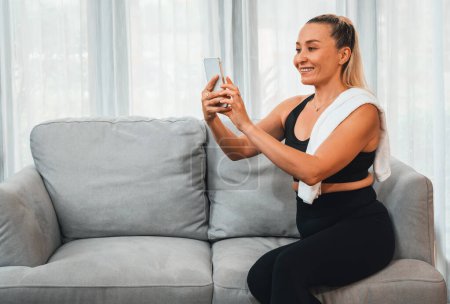 Photo for Active and sporty senior take selfie with smartphone after finishing home workout exercise. Healthy and fit body lifestyle for pensioner after retirement workout exercising at home. Clout - Royalty Free Image