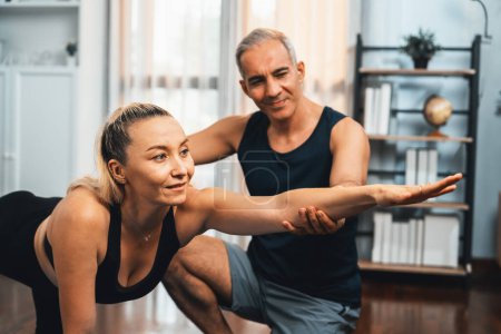Photo for Happy active senior couple in sportswear being supportive and assist on yoga posture together at home. Healthy senior man and woman lifestyle with yoga exercise. Clout - Royalty Free Image