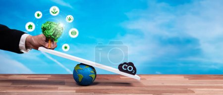 Photo for Businessman balance tree sprout on scale with CO2 emission icon, demonstrate ESG or environment social governance commitment to carbon reduction through clean energy technology. Panorama Reliance - Royalty Free Image