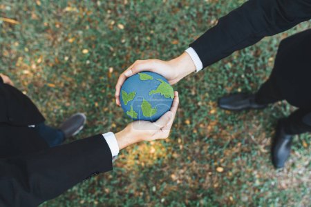 Téléchargez les photos : Concept du Jour de la Terre, vue de dessus homme d'affaires donnant globe Terre comme principe de responsabilité sociale d'entreprise RSE pour promouvoir la sensibilisation à l'environnement et embrasser ESG pour un avenir plus vert et durable. Pneumatique - en image libre de droit