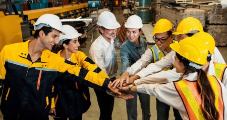 Photo for Cohesive and race diversity group of factory worker joining hands together in heavy steel industry factory exemplifying teamwork on diverse industrial engineering profession with team building concept - Royalty Free Image