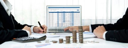 Photo for Corporate accountant use accounting software on laptop to calculate and maximize tax refunds and improve financial performance with business investment concept of growth stack coin in panorama. Shrewd - Royalty Free Image