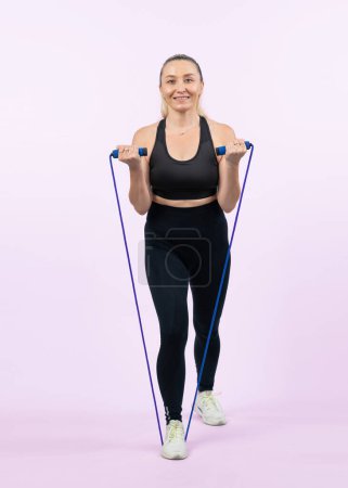 Photo for Full body length shot athletic and sporty senior woman with fitness exercising rope on isolated background. Healthy active physique and body care lifestyle senior people. Clout - Royalty Free Image