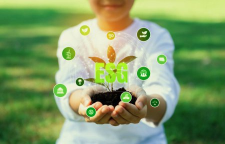 Téléchargez les photos : Petite plante nourrissante enfant avec éco icône symboliser la préservation naturelle pour la génération durable future en cultivant des plantes pour réduire les émissions de carbone et en utilisant la technologie verte ESG. Dépendance - en image libre de droit
