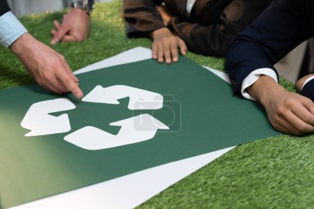 Téléchargez les photos : Recycler icône sur la table de réunion dans le bureau avec les gens d'affaires qui planifient l'investissement éco-entreprise sur la gestion des déchets comme recyclage réduire le concept de réutilisation pour un écosystème propre. Charmante. - en image libre de droit