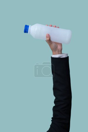 Photo for Businessmans hand holding plastic bottle on isolated background. Eco-business recycle waste policy in corporate responsibility. Reuse, reduce and recycle for sustainability environment. Quaint - Royalty Free Image