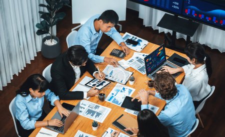 Photo for Wide top view of diverse group of business analyst team analyzing financial data report paper on meeting table. Chart and graph dashboard by business intelligence analysis. Meticulous - Royalty Free Image