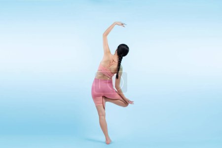 Foto de Mujer asiática en ropa deportiva haciendo ejercicio de yoga en pose de pie en la aptitud como su rutina de entrenamiento. Cuidado corporal saludable y meditación yoga estilo de vida en plena toma sobre fondo aislado. Vigoroso - Imagen libre de derechos