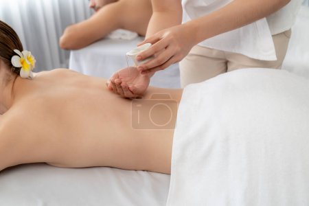 Photo for Masseur hands pouring aroma oil on couples back. Masseuse prepare oil massage procedure for customer at spa salon in luxury resort. Aroma oil body massage therapy concept. Quiescent - Royalty Free Image