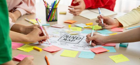 Kreatives Brainstorming des Geschäftsteams über Marketingstrategie und Businessplan mittels Mind Mapping. Startup-Teams arbeiten zusammen, um ihre Ideen zu Papier zu bringen. Konzentrieren Sie sich auf die Hand. Nahaufnahme. Bunt gemischt.