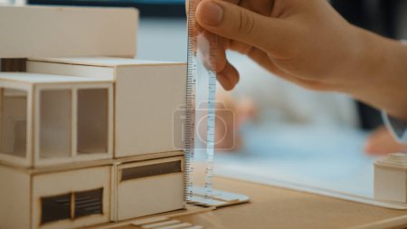 Photo for Closeup image of skilled professional engineer hand using ruler measures house model on table with blurred background. Creative design, architect design, architectural equipment concept. Immaculate. - Royalty Free Image
