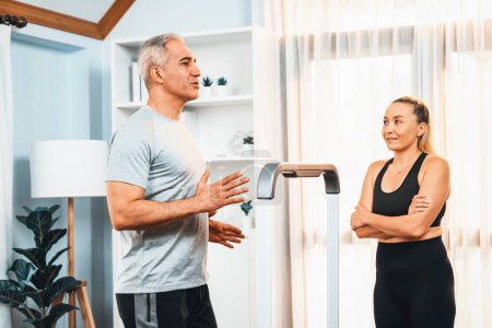 Photo for Active senior couple running on tread running machine at home together as fitness healthy lifestyle and body care after retirement for pensioner. Clout - Royalty Free Image