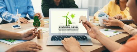 Photo for Renewable energy logo displayed on green business laptop while business team represented green design to customer. ESG environment social governance and Eco conservative concept. Closeup. Delineation. - Royalty Free Image