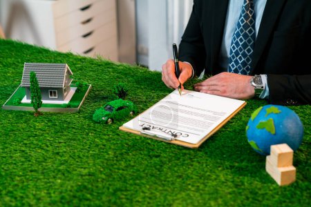 Foto de Empresario o CEO en oficina firman acuerdo de regulación ambiental para salvar la Tierra con la utilización sostenible de la energía y la reducción de CO2 para un futuro más verde. Pintoresco - Imagen libre de derechos