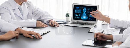 Téléchargez les photos : Groupe de médecins ou de chercheurs étudiant les maladies génétiques dans l'ADN avec ordinateur portable, analyser les données génétiques, formuler des stratégies de traitement médical et élaborer un plan de soins de santé avec une solution innovante. Néotérique - en image libre de droit